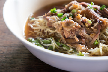 Stewed pork noodle soup with morning glory and bean sprout.