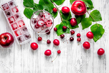 Apple, pulm, cherry, ice for summer fruit drink on wooden table background top view copyspace