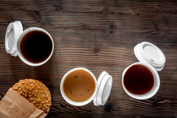 Coffee take out. Coffee cups with covers and cookies on wooden table backound top view copyspace