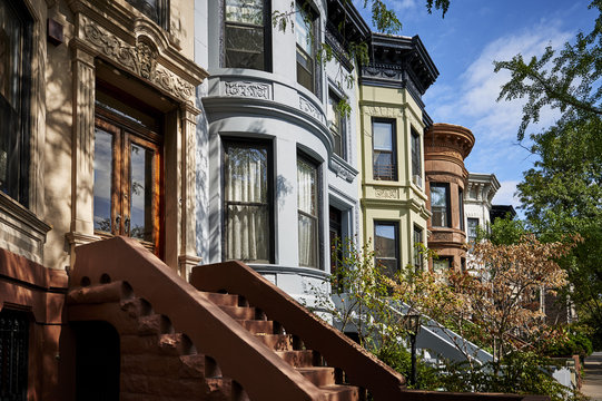 a row of colorful brownstone apartments