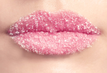 Lips of beautiful young woman covered with sugar, closeup
