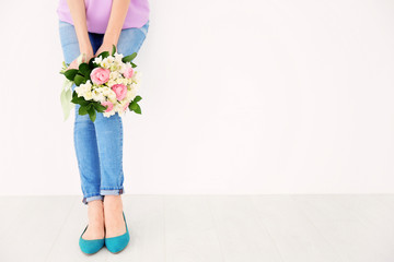 Young woman holding beautiful bouquet with freesia flowers on white background