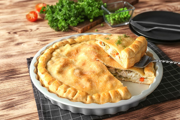 Baking dish with turkey pot pie on wooden background