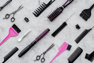 Pattern of combs and hairdresser tools on grey table background top view