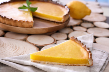 Piece of delicious lemon pie on cotton napkin, closeup