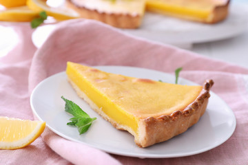 Plate with delicious lemon pie on table, closeup