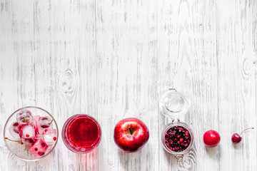 Summer fruit drink with cranberry, apple and pulm on wooden table top view copyspace