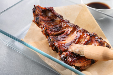 Baking tray with delicious pork ribs on table, closeup