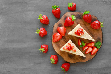 Composition with two pieces of homemade cake with strawberries on table