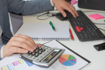closeup pen on paperwork accounts with man use computer to save data in background. accounting concept