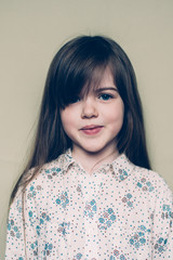 Fototapeta premium portrait of a pretty little cute girl, isolated on a light background