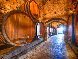 Winery cellar with special edition wine aging in barrels for a few years until it is ready at Barolo vineyard
