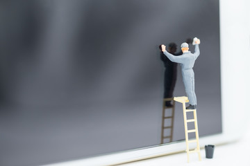 Worker miniature figure stand on ladder to wipe and cleaning smart phone glass screen.