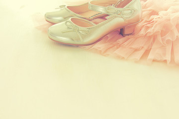 Vintage tulle pink chiffon dress and silver shoes on wooden white floor