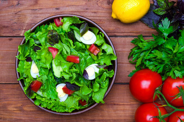 Fresh dietary salad on a wooden table, top view.