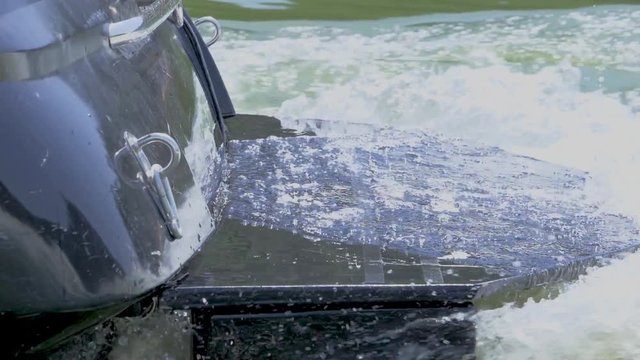 Rear wakeboard boat sailing and splashing. Slow motion