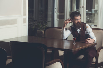 Man drinking wine served with two glasses