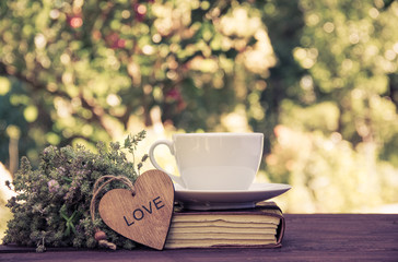 A cup of summer tea with thyme. A cup of tea and a stack of books.. Romantic concept