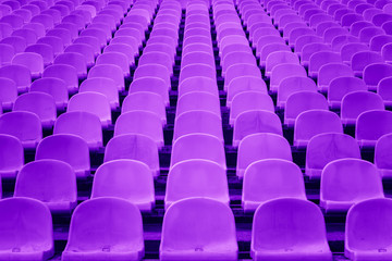 Chairs in the stadium symmetrical and textured painted in violet. Perspective and symmetry. Abstract wallpaper. 