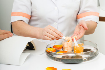 Woman applying cream on hand using spatula