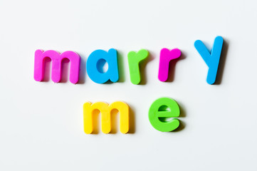 Fridge magnets magnetic letters spelling out "marry me"