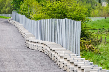 Long temporary security fence being built in a field during a security operation