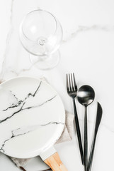 Set of cutlery knife, spoon, fork, plate, wine glass. White marble background. Top view copy space