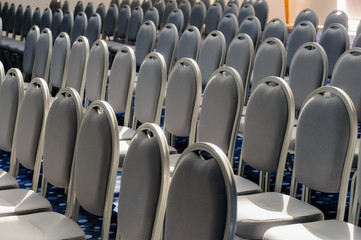 Grey chairs lined up for a conference in a large hall