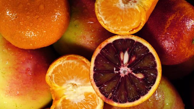 Sweet juicy vegetables: apples, mandarines and oranges refreshing by water. Top close up rotation in 4K. Beautiful healthy food concept.
