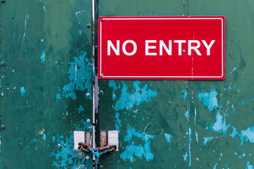 Locked steel door at an industrial site saying "No Entry"