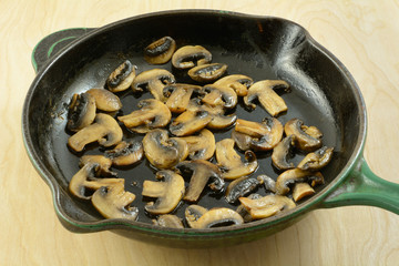 Sauteed sliced white button mushrooms in cast iron skillet