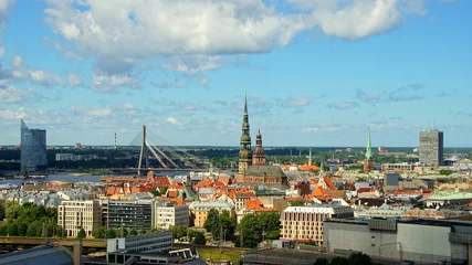 Deurstickers Zonnig breed stadspanorama van Riga met markthallen en bruggen over de rivier de Daugava © globetrotter1