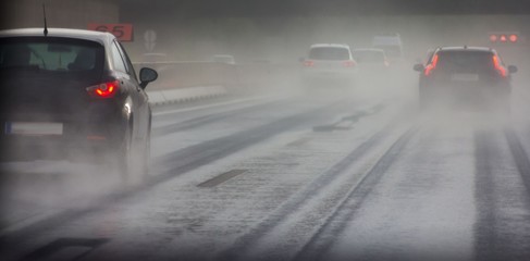 Fototapeta na wymiar Cars driving on wet rainy road in bad weather 