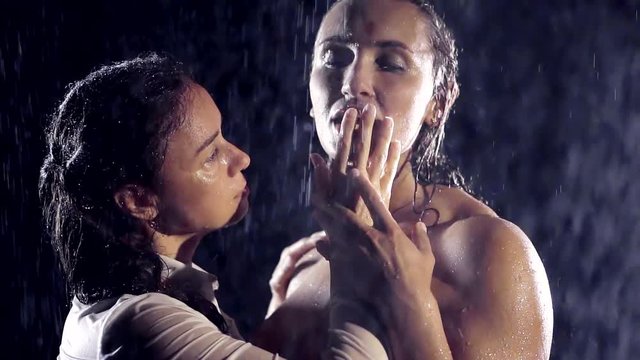 girls homosexual orientation are naked in the rain. they are very excited and play with each other. one touches the face of another hand. fingers stroking the lips and gives them a lick