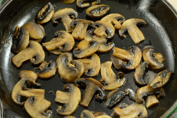 Close up of sliced sauteed mushrooms in cast iron pan