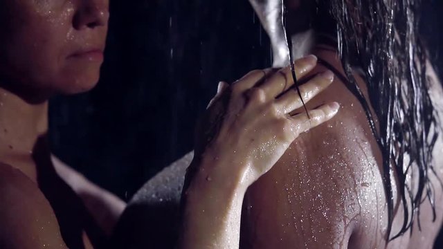 close-up. slow motion. woman's hand glides along the wet shoulder of the girl. they are lesbians and love each other