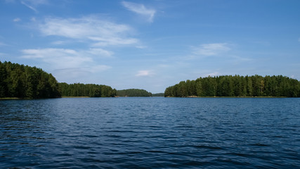 Finnish lake on a clear summer day with lush green islands and coasts