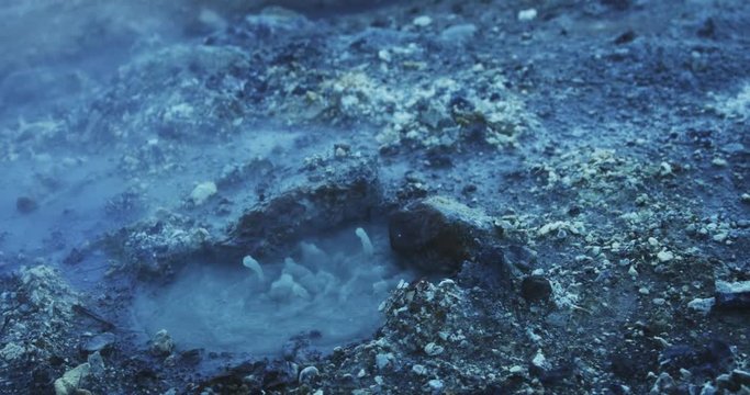 Close up, boiling mud pit in slow motion