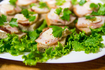 Traditional snack for Russian and Ukrainian people on the holidays. A sandwich with bacon, garlic and parsley under the glass of genuine Russian vodka