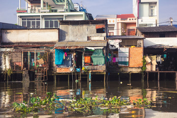 Fototapeta na wymiar Small poor houses on water in Vietnam.