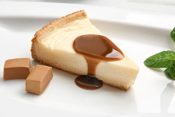 Plate with delicious cheesecake and caramel sauce, closeup