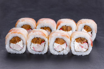 Delicious uramaki sushi rolls with crab meat, omelet and cream cheese covered with redfish