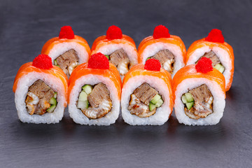 Tasty multicolored uramaki sushi roll with salmon and omelet, decorated with caviar. Restaurant menu, Japanese food art