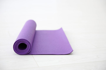 Purple yoga mat on light background