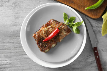 Delicious grilled spare ribs with chili on wooden table, top view