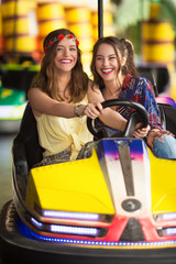 Girlfriends driving a bumper car together