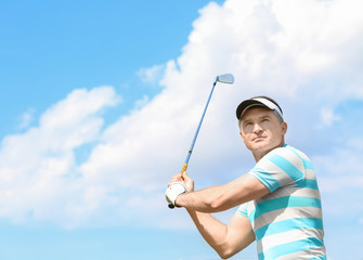 Young man playing golf on course in sunny day