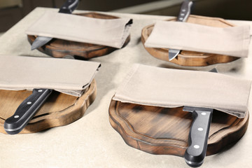 Knives with napkins and wooden boards on kitchen table. Cooking classes concept