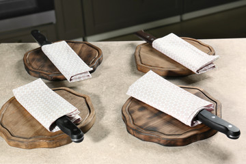 Knives with napkins and wooden boards on kitchen table. Cooking classes concept