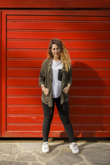 lovely young woman standing in front of red garage door
